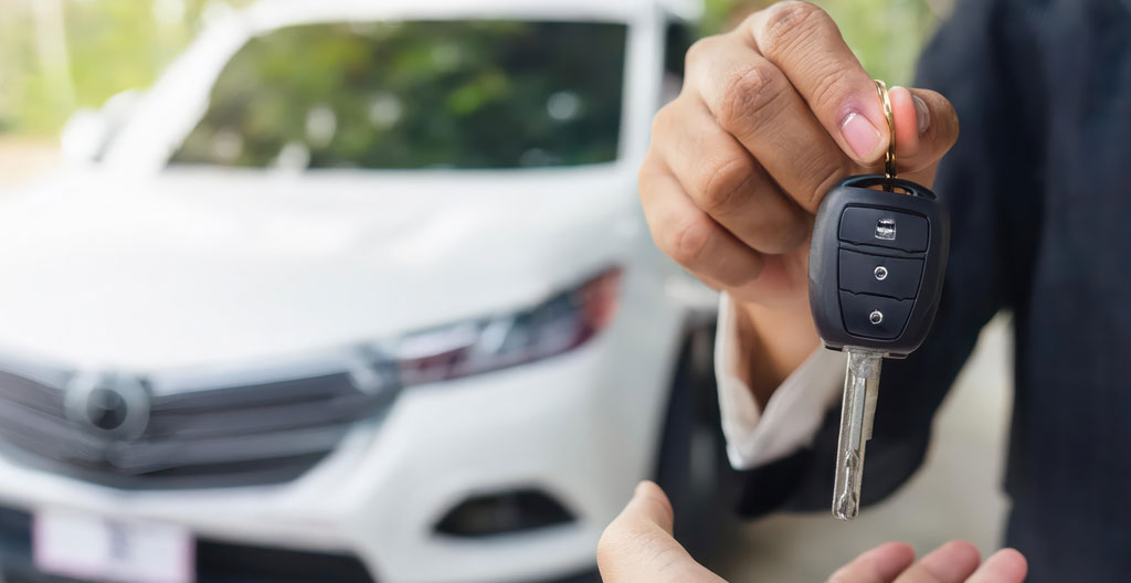 Professionnel inspectant l'état de carrosserie d'une voiture lors de la restitution