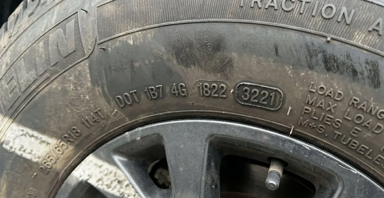 Vue macro détaillée d'un code DOT gravé sur le flanc d'un pneu automobile