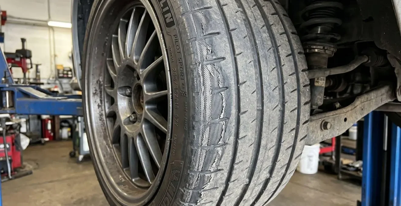 Gros plan sur l'usure intérieure caractéristique d'un pneu avec carrossage négatif excessif