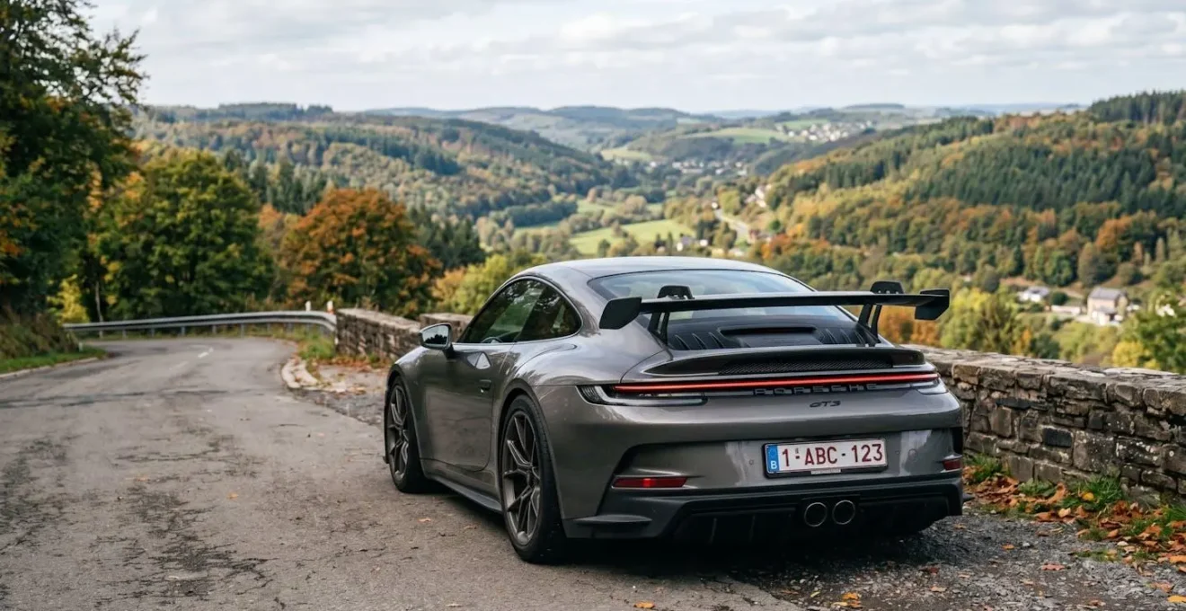 Arrière d'une voiture de sport avec plaque d'immatriculation belge floutée, stationnée dans les collines ardennaises